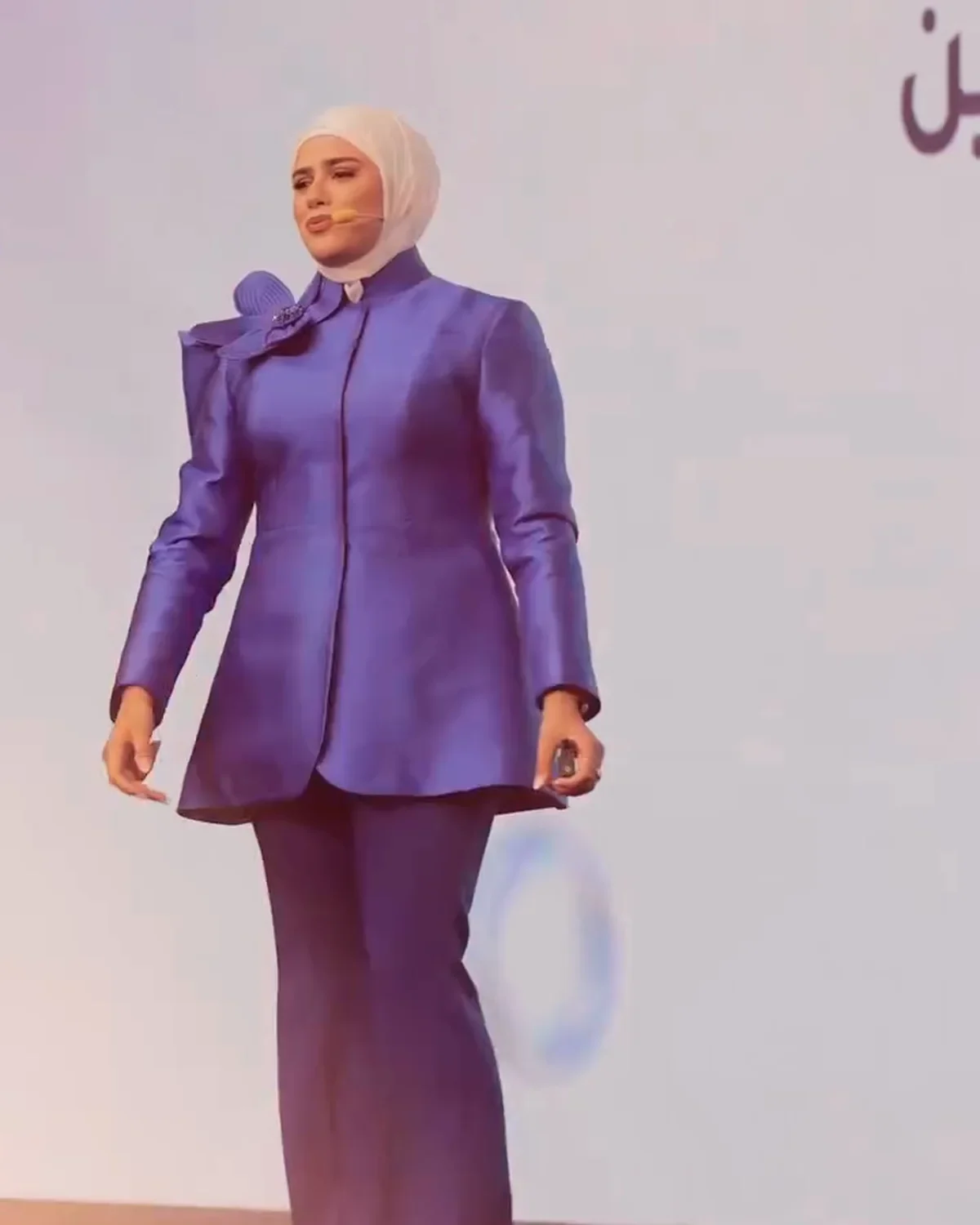 Razan Cheaito speaking on stage in a blue suit