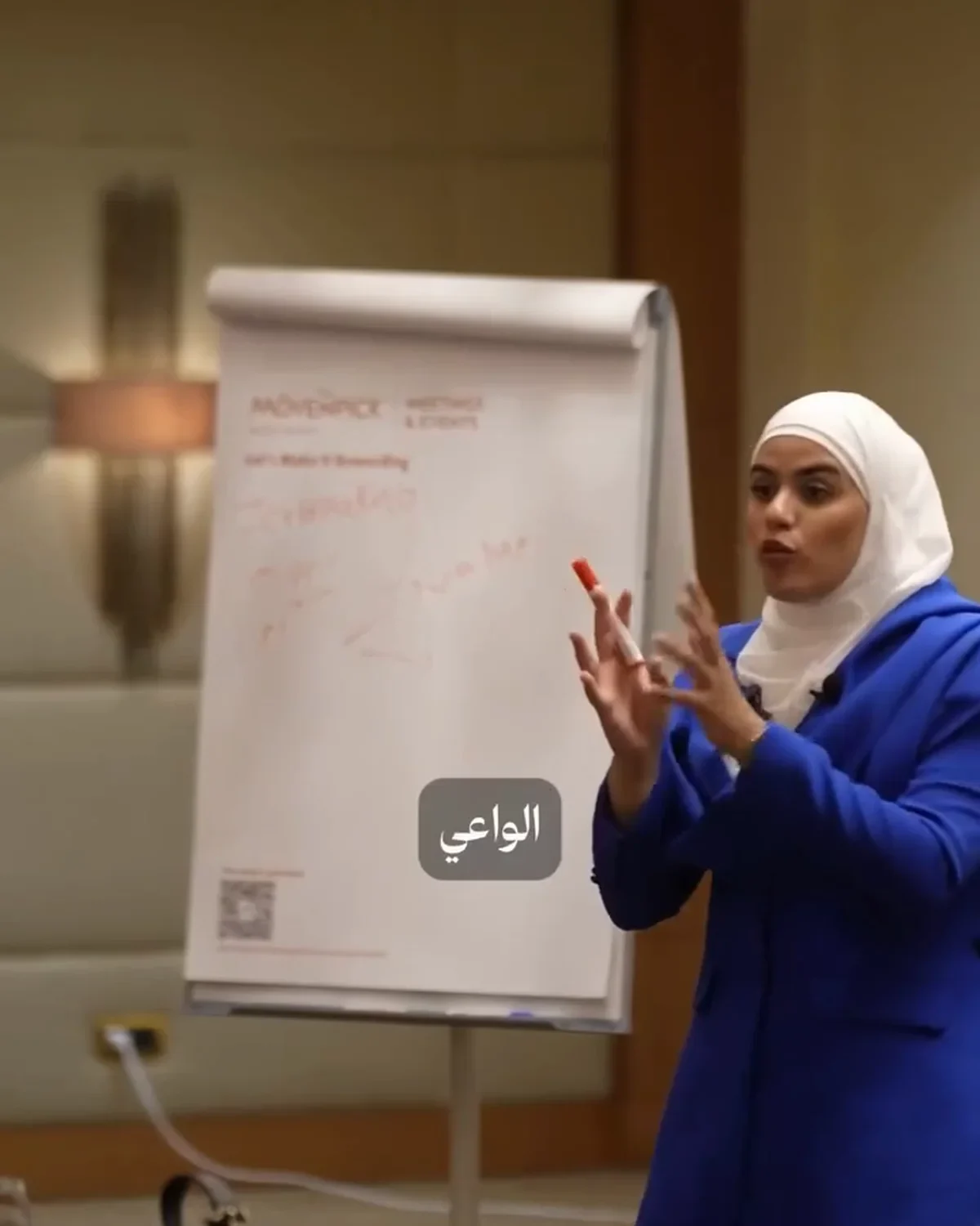 Razan Cheaito leading a workshop beside a presentation board
